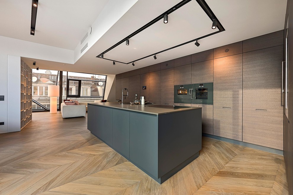 Ispirazione per una cucina contemporanea di medie dimensioni con ante lisce, ante marroni, elettrodomestici neri e pavimento in legno massello medio