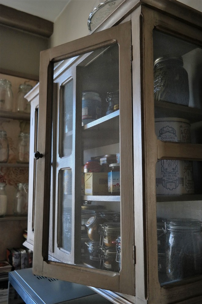 Cette image montre une cuisine ouverte rustique en U et bois clair de taille moyenne avec un placard à porte affleurante, plan de travail en marbre, une crédence en céramique et un électroménager noir.