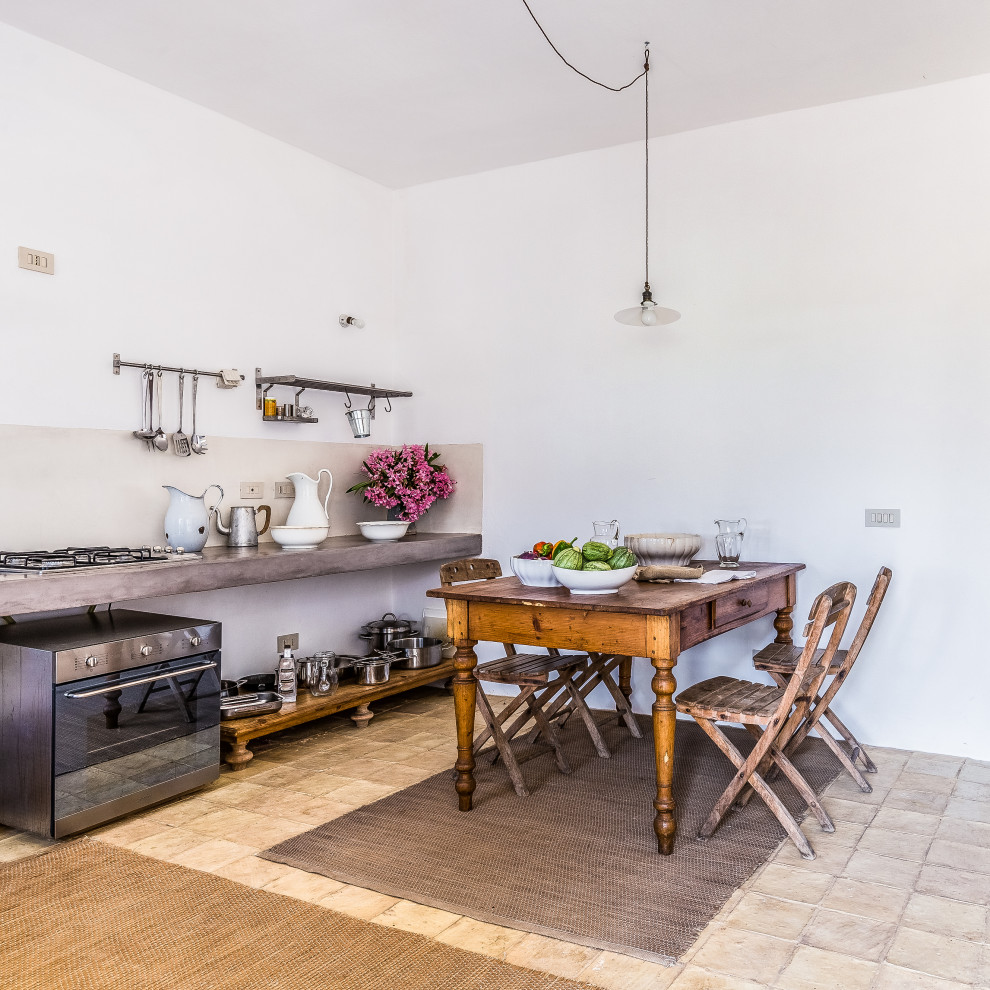 Einzeilige Mediterrane Küche mit offenen Schränken, Küchenrückwand in Grau, Küchengeräten aus Edelstahl und grauer Arbeitsplatte in Sonstige