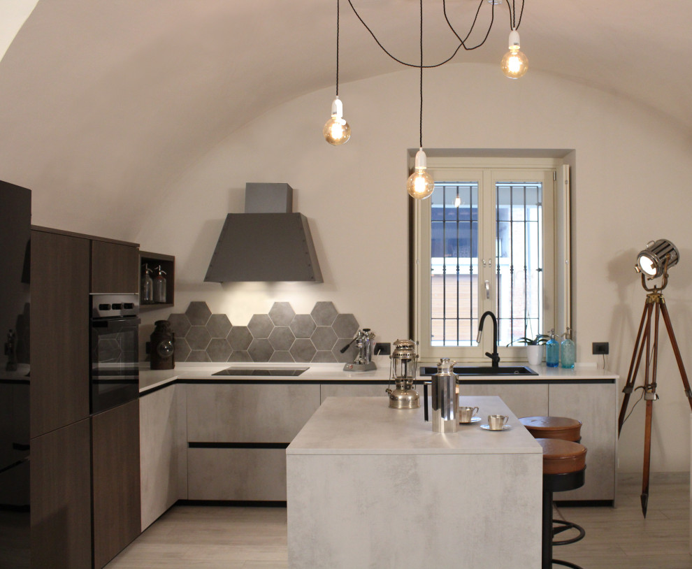 Bild på ett mellanstort industriellt vit vitt kök, med en enkel diskho, släta luckor, grå skåp, bänkskiva i kvarts, grått stänkskydd, stänkskydd i porslinskakel, svarta vitvaror, klinkergolv i porslin och en köksö
