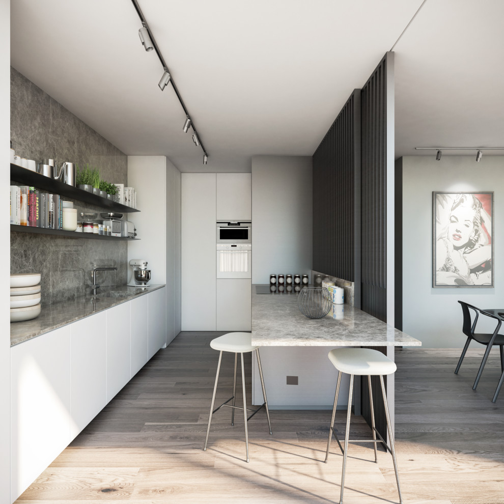 Immagine di una grande cucina parallela minimal chiusa con ante lisce, ante bianche, top in marmo, paraspruzzi in marmo e penisola