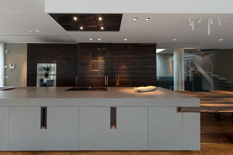 Inspiration for a large contemporary single-wall kitchen/diner in Other with an island, an integrated sink, flat-panel cabinets, dark wood cabinets, composite countertops, stainless steel appliances, dark hardwood flooring and grey worktops.