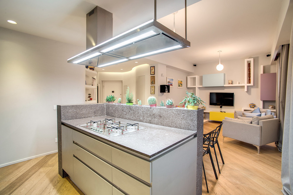 Esempio di un cucina con isola centrale design con ante lisce, top alla veneziana, paraspruzzi grigio e parquet chiaro