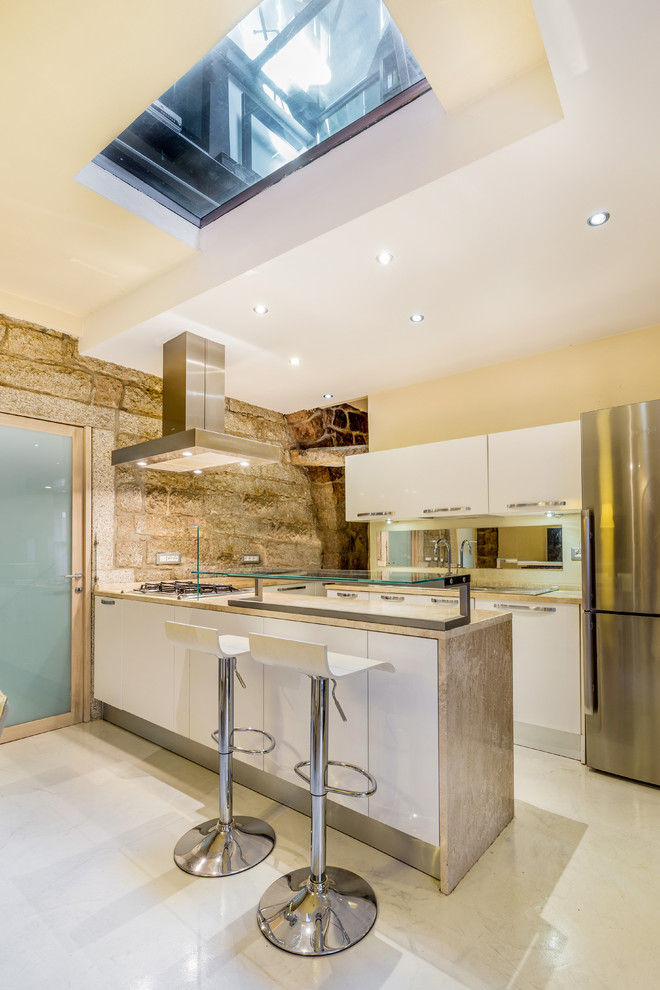 Foto di una cucina ad ambiente unico design di medie dimensioni con ante lisce, ante bianche, top in marmo, elettrodomestici in acciaio inossidabile, pavimento in marmo e penisola
