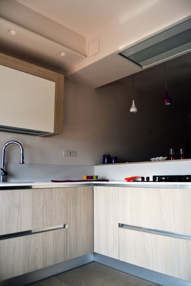 Moderne Wohnküche in L-Form mit Einbauwaschbecken, hellen Holzschränken, Küchenrückwand in Weiß, Keramikboden und Halbinsel in Bari