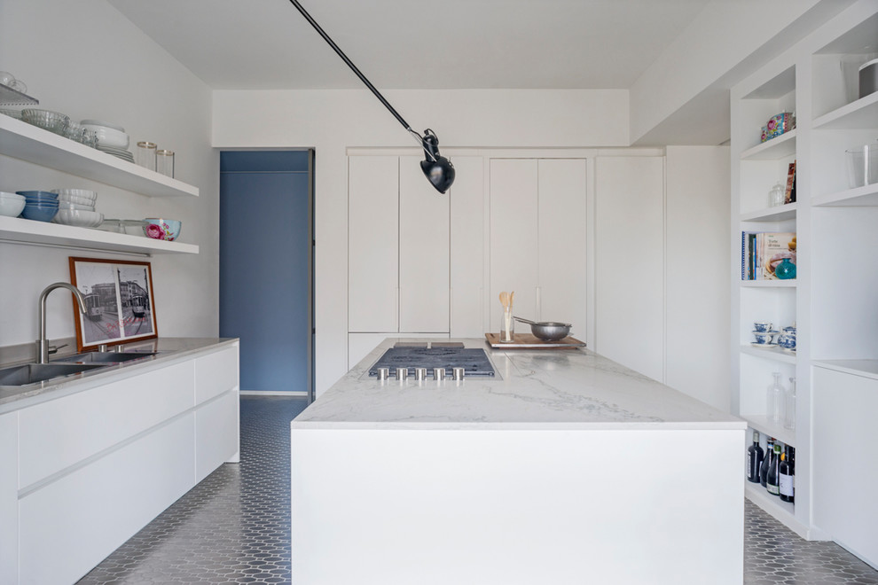 Large coastal single-wall enclosed kitchen in Milan with flat-panel cabinets, white cabinets, marble worktops, white splashback and an island.
