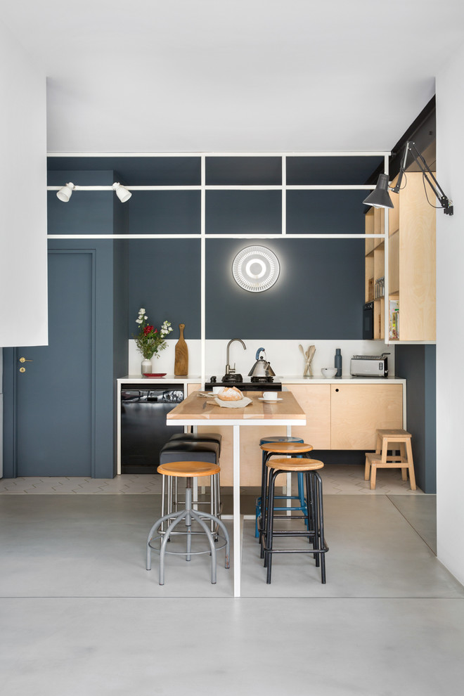 Diseño de cocina lineal contemporánea abierta con armarios abiertos, puertas de armario de madera clara, salpicadero blanco, electrodomésticos negros, suelo de cemento y suelo gris