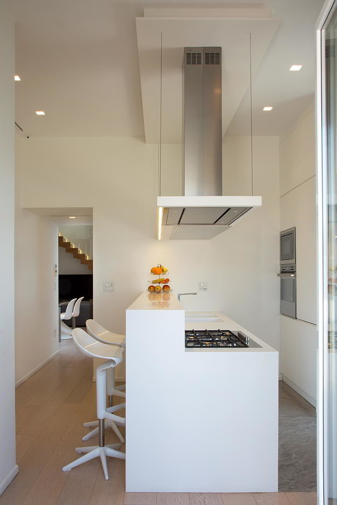Foto di una cucina minimal con ante bianche e elettrodomestici in acciaio inossidabile