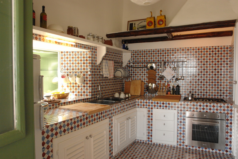 Inredning av ett eklektiskt kök, med en dubbel diskho, luckor med lamellpanel, vita skåp, kaklad bänkskiva, flerfärgad stänkskydd, stänkskydd i mosaik, rostfria vitvaror och klinkergolv i keramik