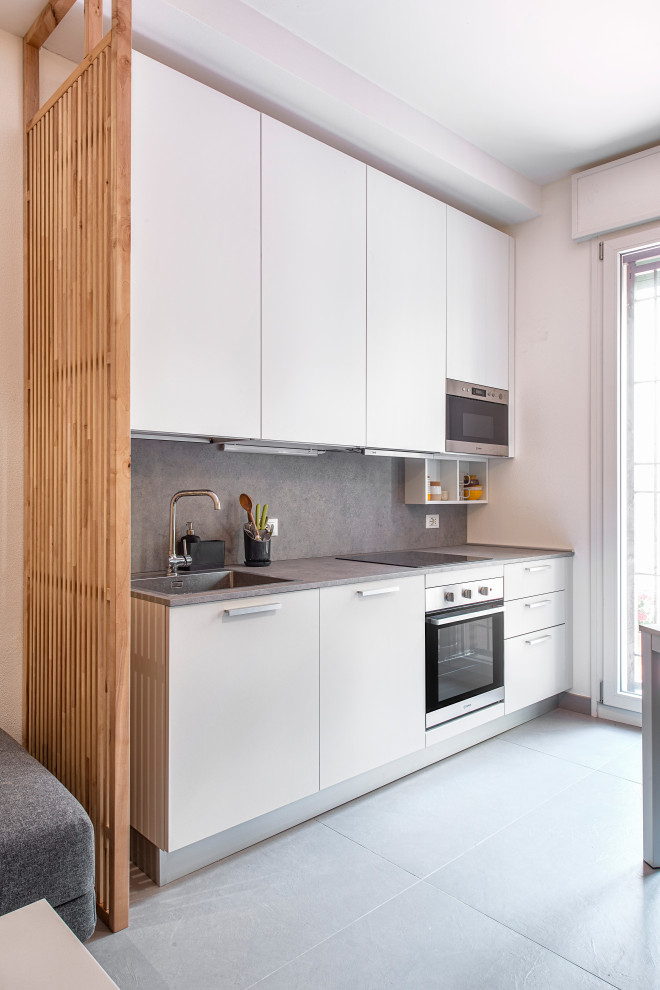 Immagine di una piccola cucina contemporanea con lavello a vasca singola, ante lisce, ante bianche, top in laminato, pavimento in gres porcellanato, pavimento grigio e top grigio