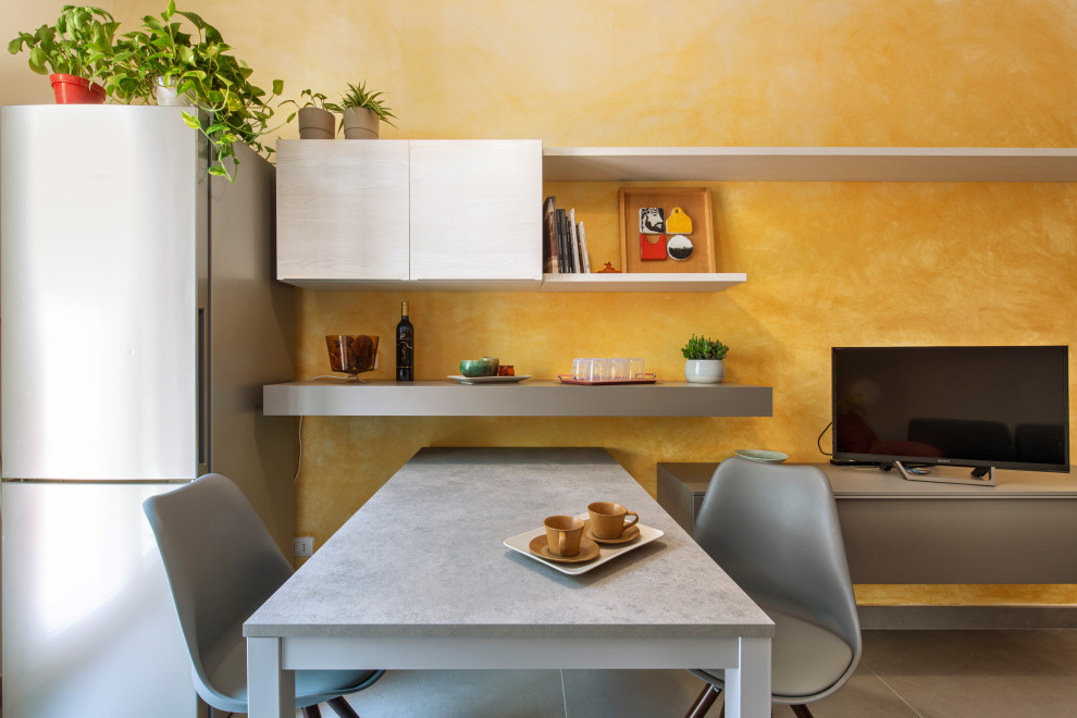 Immagine di una piccola cucina abitabile design con ante lisce, ante bianche, top in laminato, elettrodomestici colorati, pavimento in gres porcellanato, pavimento grigio e top grigio