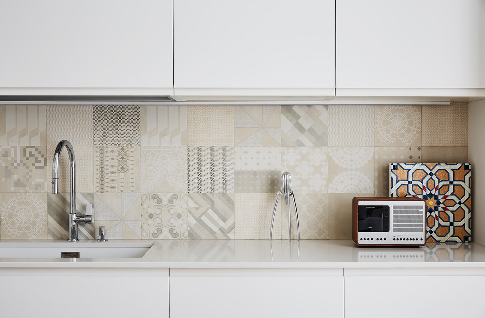 Inspiration for a mid-sized scandinavian single-wall open concept kitchen remodel in Milan with an undermount sink, flat-panel cabinets, white cabinets, quartz countertops, multicolored backsplash, mosaic tile backsplash and an island