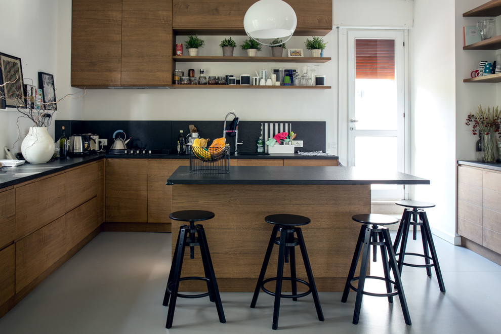 Idée de décoration pour une cuisine minimaliste en L et bois foncé avec un placard à porte plane, une crédence noire et îlot.