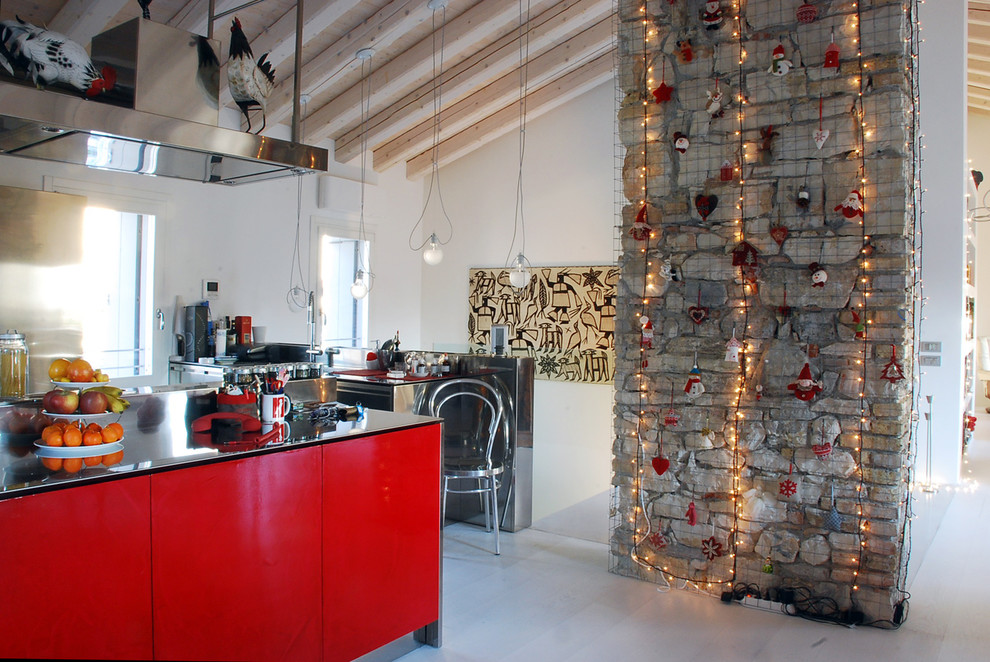 Foto på ett industriellt grå parallellkök, med släta luckor, röda skåp, bänkskiva i rostfritt stål, en köksö och grått golv