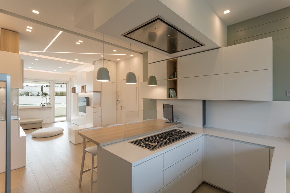 Trendy u-shaped light wood floor kitchen photo in Rome with a drop-in sink, white cabinets, quartz countertops, stainless steel appliances and white countertops