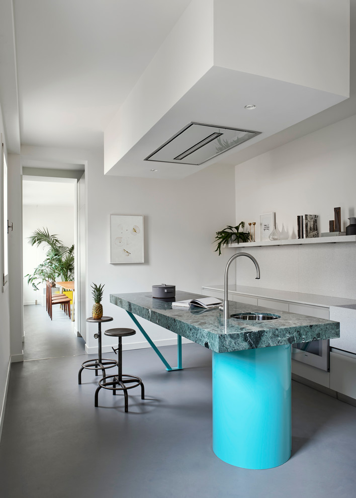 Modern inredning av ett linjärt kök, med en undermonterad diskho, öppna hyllor, betonggolv, en köksö och grått golv