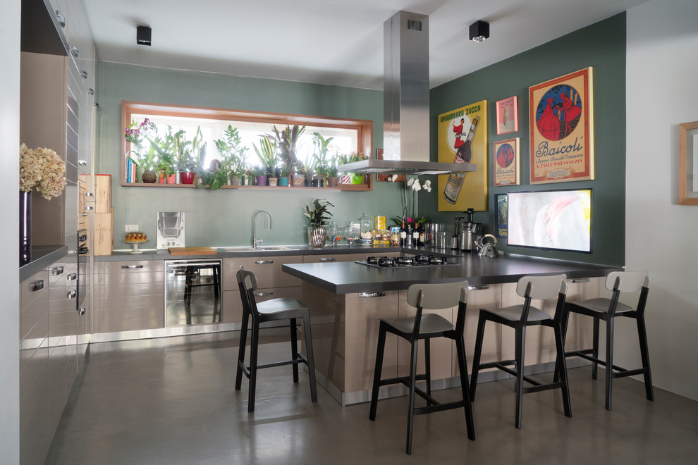 Inspiration for a large contemporary u-shaped kitchen/diner in Milan with a built-in sink, brown cabinets, concrete flooring, a breakfast bar, grey floors, grey worktops, flat-panel cabinets, green splashback and stainless steel appliances.