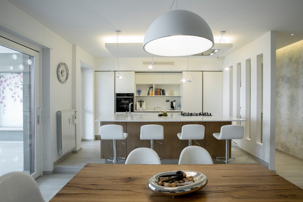 Источник вдохновения для домашнего уюта: прямая кухня среднего размера в современном стиле с обеденным столом, плоскими фасадами, белыми фасадами и островом