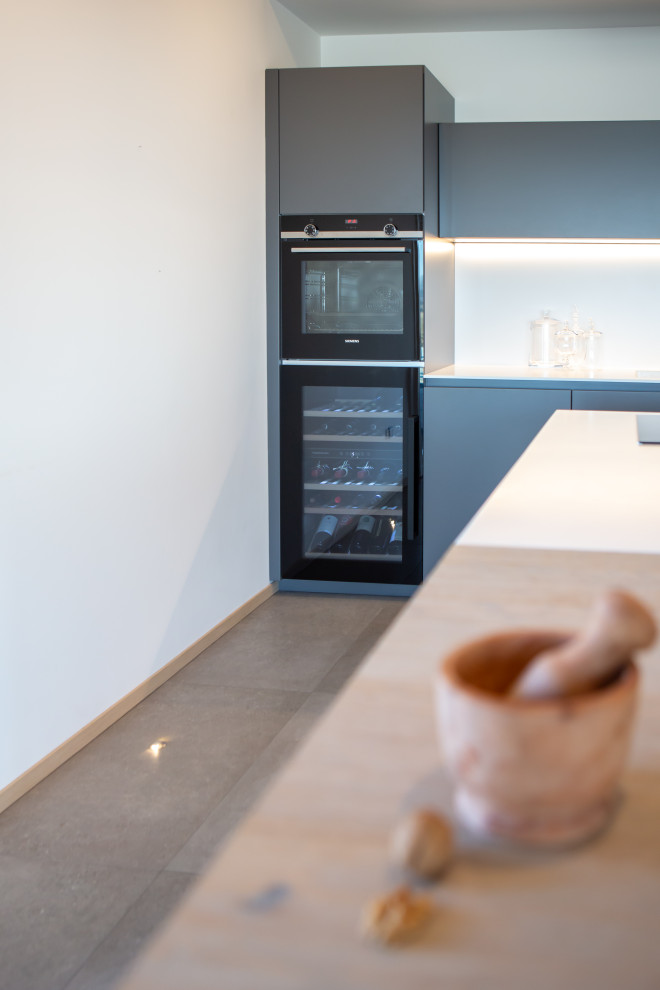 Immagine di una cucina parallela minimalista di medie dimensioni con pavimento in legno massello medio e pavimento beige