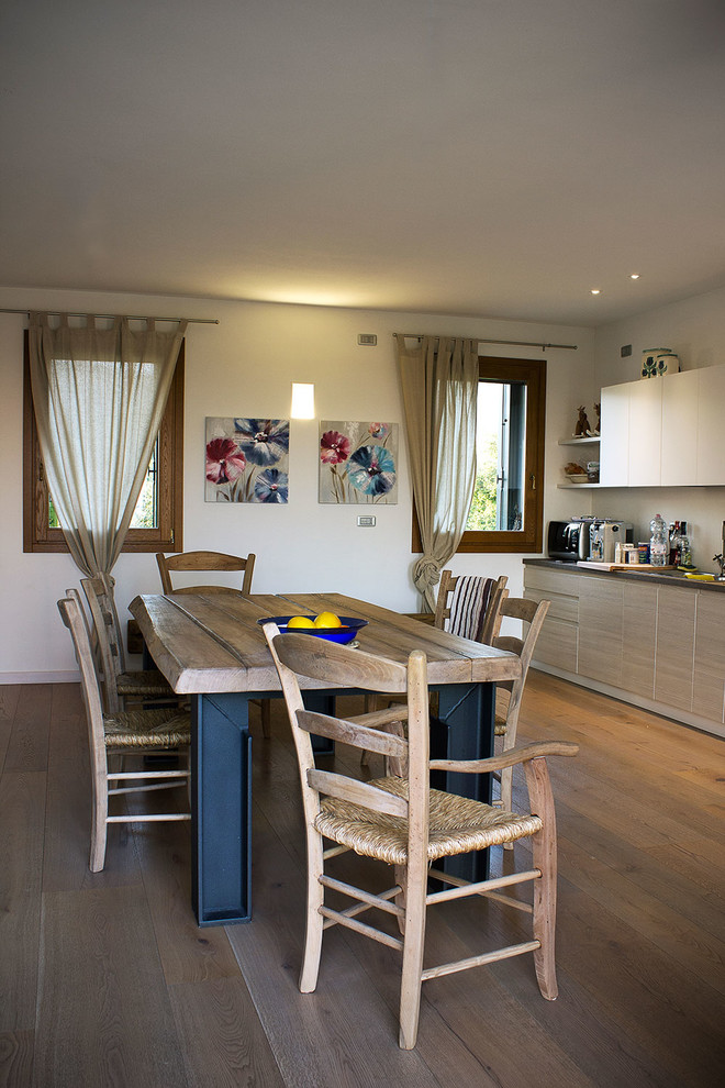 Immagine di una cucina country di medie dimensioni con ante lisce, ante in legno chiaro, pavimento in legno massello medio e pavimento marrone