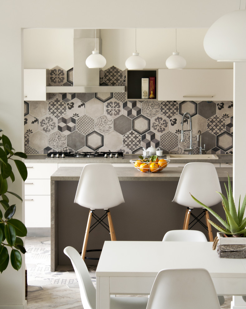 This is an example of a medium sized contemporary single-wall kitchen/diner in Turin with multi-coloured splashback, flat-panel cabinets, white cabinets, ceramic splashback and an island.