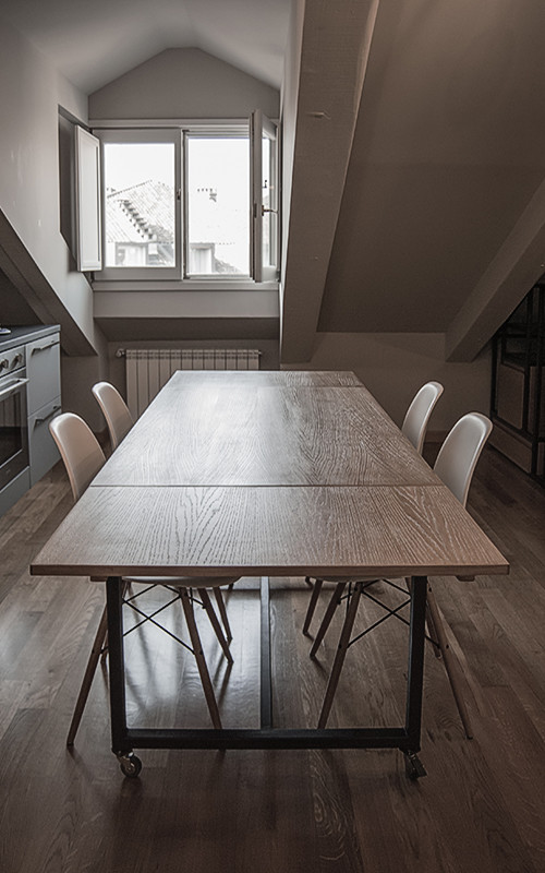 Foto di una sala da pranzo aperta verso la cucina industriale di medie dimensioni con parquet scuro e pavimento marrone