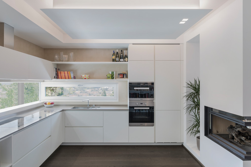 Foto di una cucina a L minimalista chiusa e di medie dimensioni con ante lisce, ante bianche e nessuna isola