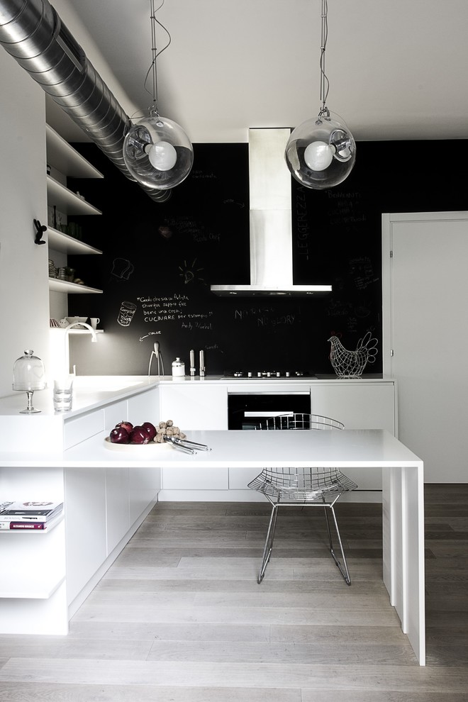 Exempel på ett litet modernt kök, med släta luckor, vita skåp, bänkskiva i koppar, svart stänkskydd, svarta vitvaror och målat trägolv