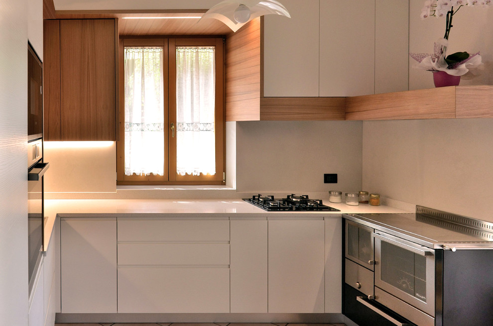 Foto di una piccola cucina minimalista con lavello a doppia vasca, ante lisce, ante bianche, top in superficie solida, elettrodomestici in acciaio inossidabile e top bianco