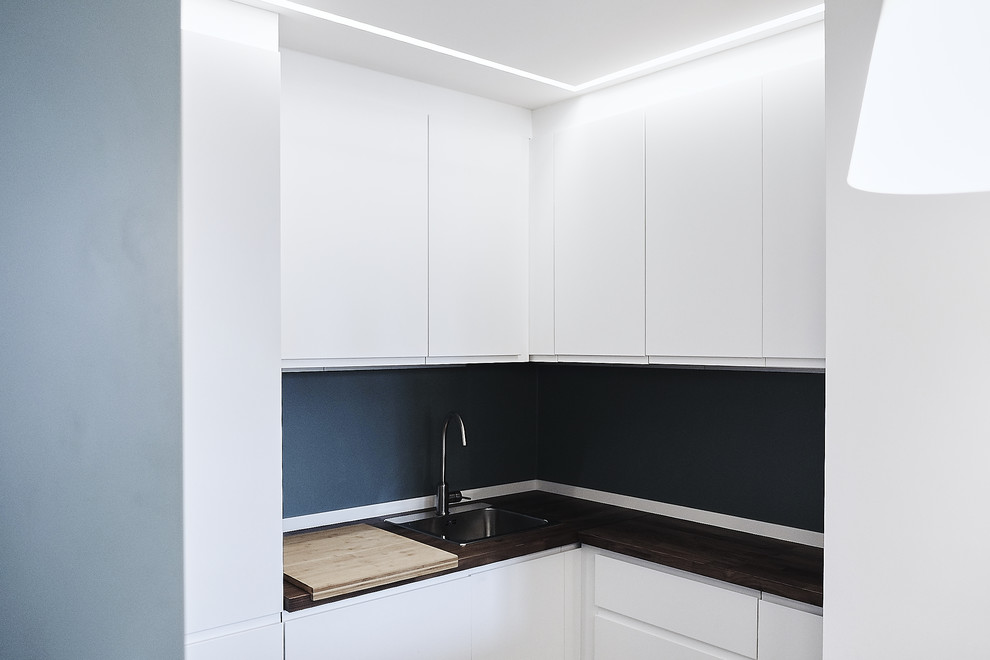 Kleine, Offene Moderne Küche in U-Form mit flächenbündigen Schrankfronten, weißen Schränken und Arbeitsplatte aus Holz in Mailand