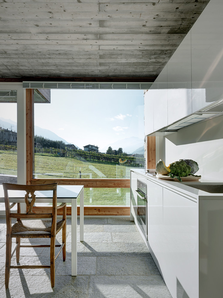 Esempio di una cucina contemporanea di medie dimensioni con ante lisce, ante bianche, paraspruzzi bianco, nessuna isola, pavimento grigio e top bianco