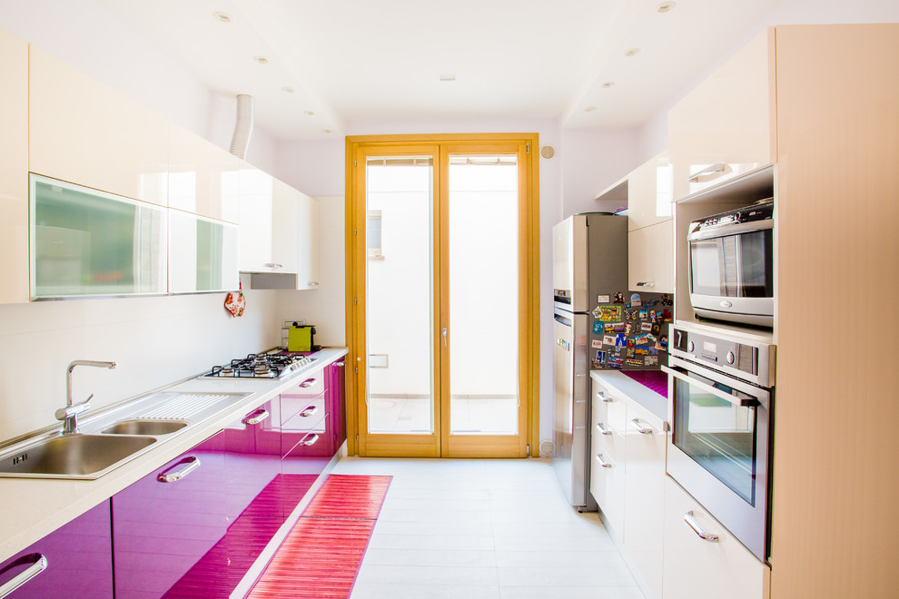 カリアリにある中くらいなコンテンポラリースタイルのおしゃれなキッチン (フラットパネル扉のキャビネット、磁器タイルの床、白い床、ダブルシンク、紫のキャビネット、シルバーの調理設備、アイランドなし) の写真