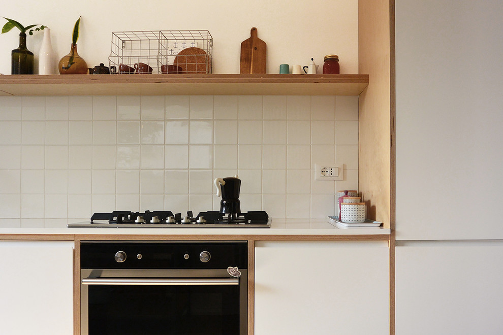 Photo of a medium sized scandinavian l-shaped open plan kitchen in Milan with a single-bowl sink, flat-panel cabinets, white cabinets, quartz worktops, white splashback, porcelain splashback, stainless steel appliances, light hardwood flooring and no island.