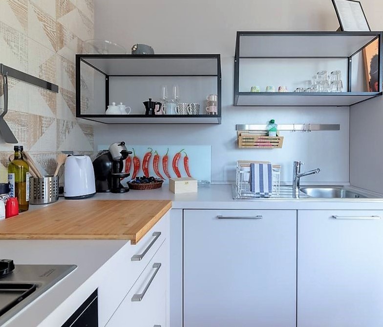 Immagine di una piccola cucina minimal con lavello da incasso, ante lisce, ante bianche, top in laminato, paraspruzzi grigio, paraspruzzi in gres porcellanato, parquet scuro, pavimento marrone e top bianco