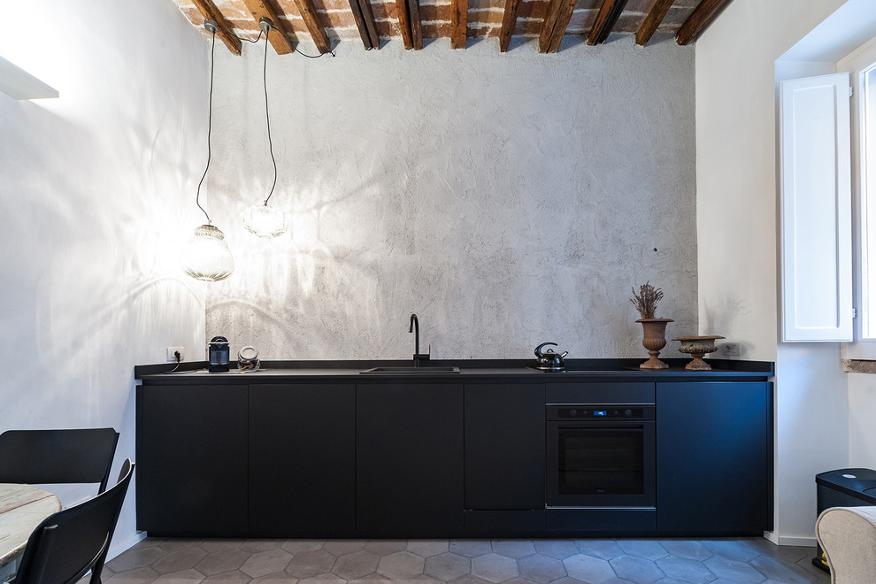 Ejemplo de cocina contemporánea con armarios con paneles lisos y puertas de armario negras