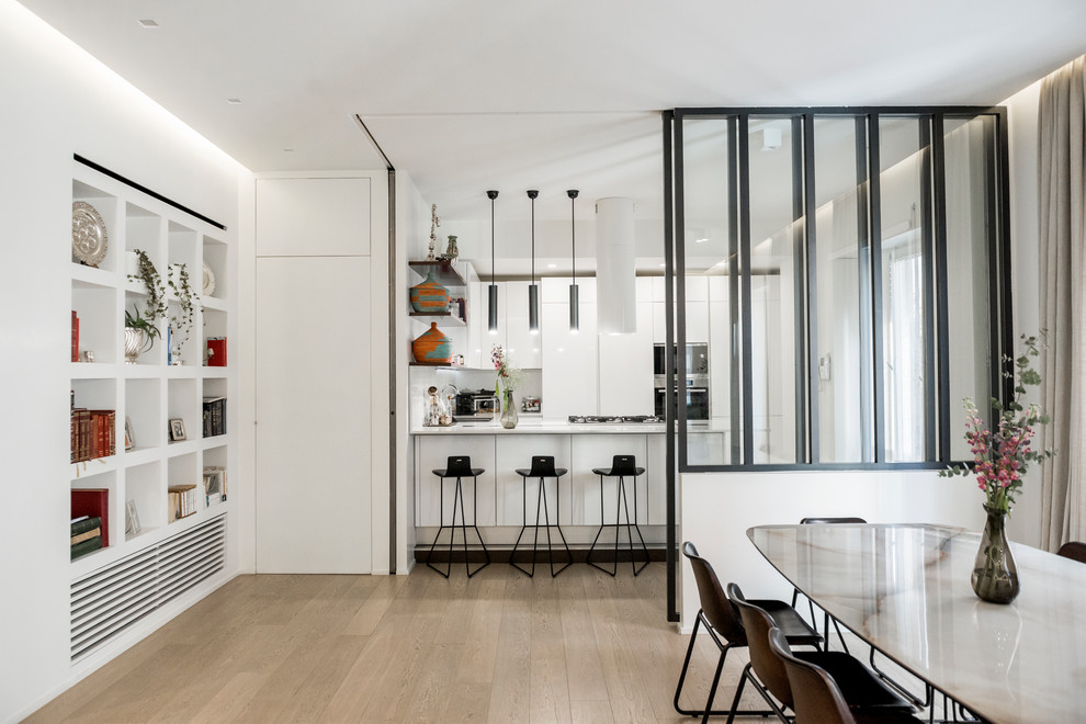 Moderne Küche in U-Form mit flächenbündigen Schrankfronten, weißen Schränken, Küchengeräten aus Edelstahl, hellem Holzboden, Halbinsel, beigem Boden und weißer Arbeitsplatte in Rom