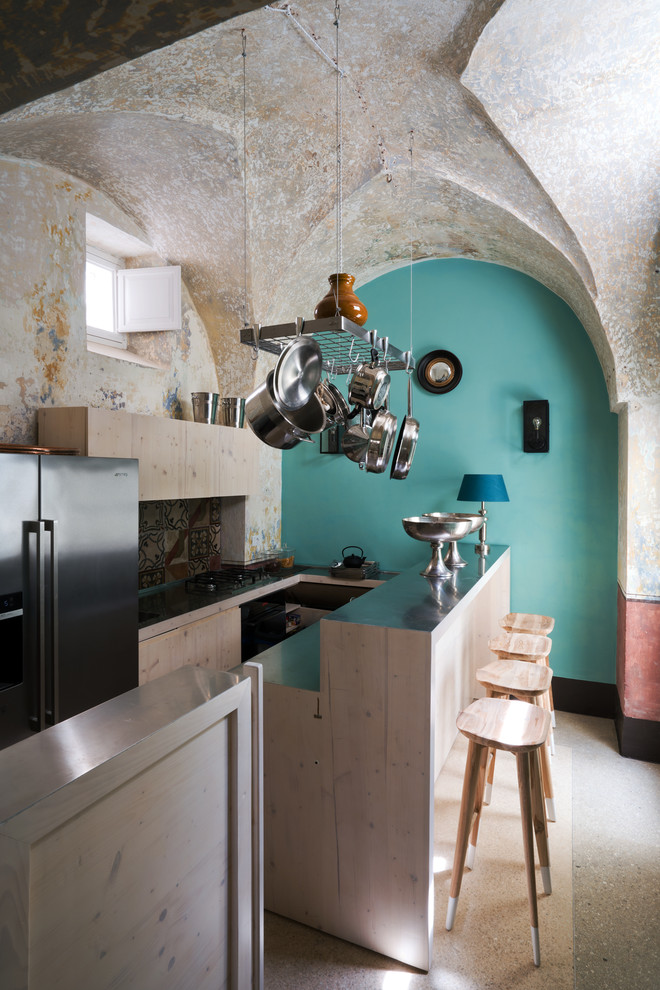 Mediterrane Küchenbar in U-Form mit flächenbündigen Schrankfronten, hellen Holzschränken, Edelstahl-Arbeitsplatte, bunter Rückwand, Küchengeräten aus Edelstahl und Halbinsel in Mailand
