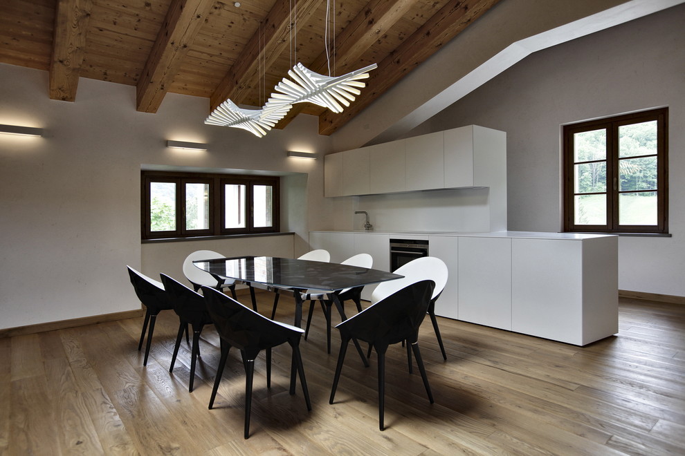 Immagine di una cucina minimalista con ante lisce, ante bianche, paraspruzzi bianco e pavimento in legno massello medio