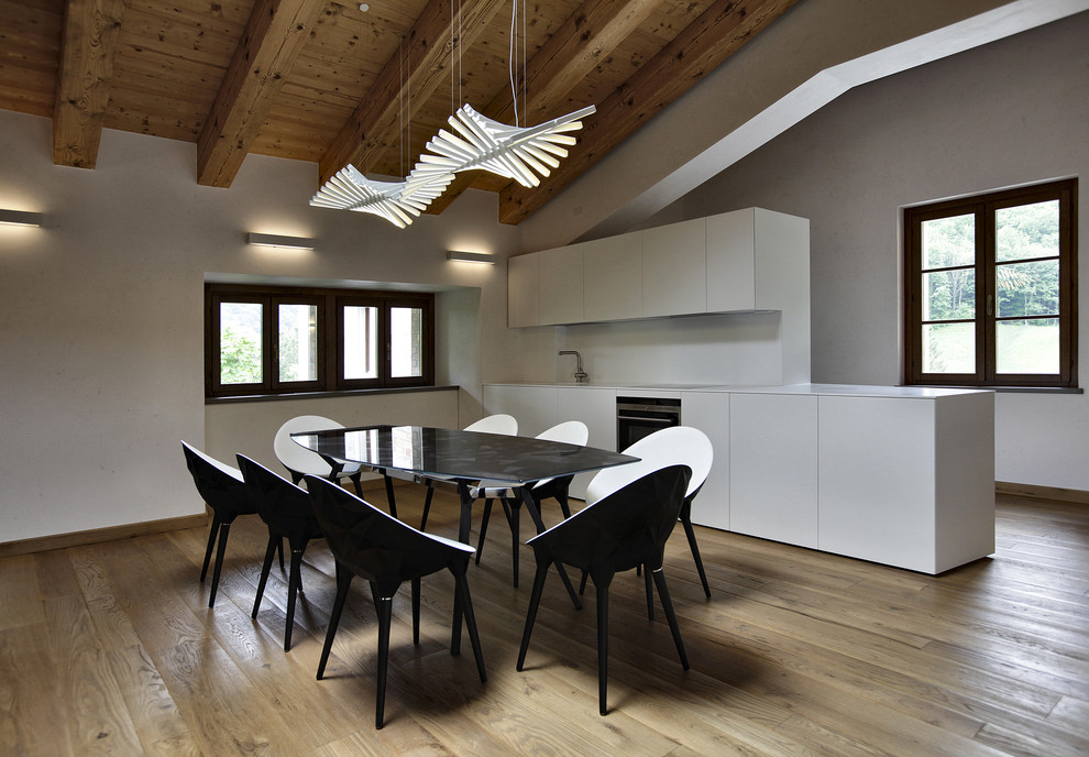 Idee per una cucina moderna di medie dimensioni con ante lisce, paraspruzzi bianco, elettrodomestici in acciaio inossidabile, parquet chiaro e pavimento beige