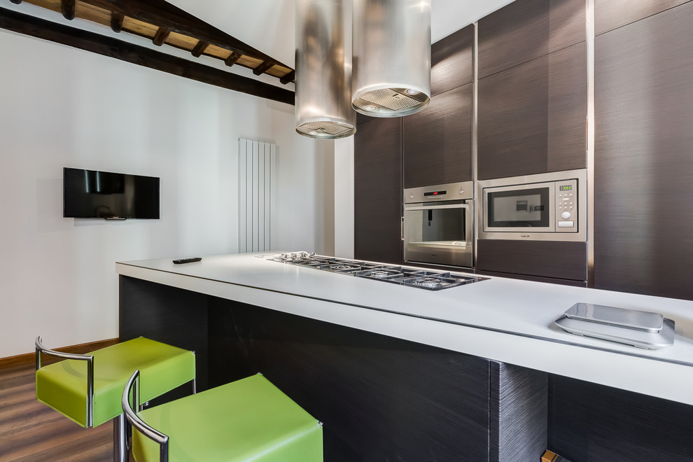 Immagine di una cucina contemporanea di medie dimensioni con lavello sottopiano, ante in legno scuro, top in laminato, elettrodomestici in acciaio inossidabile e pavimento in legno massello medio