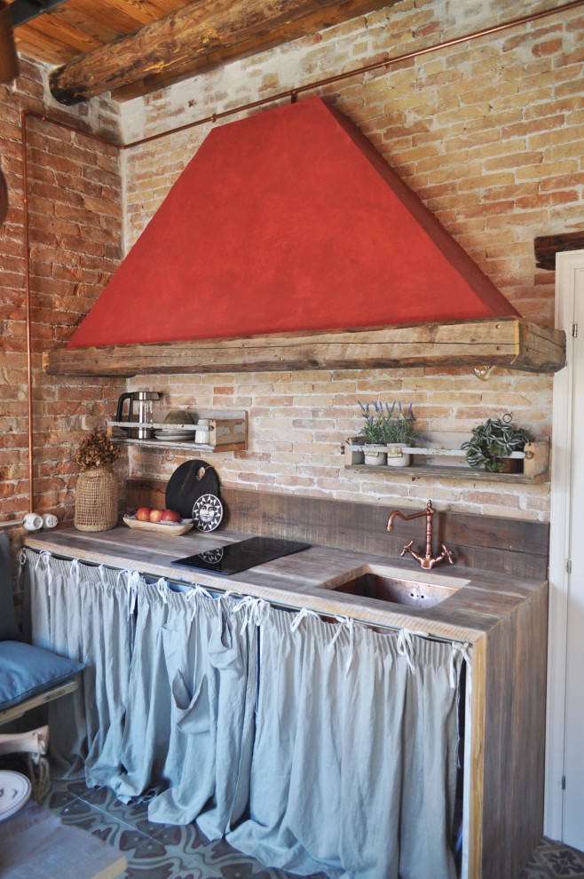 Cette photo montre une cuisine industrielle avec un évier encastré, un plan de travail en bois, une crédence rouge, une crédence en brique, un sol multicolore, un plan de travail marron, poutres apparentes et un plafond en bois.