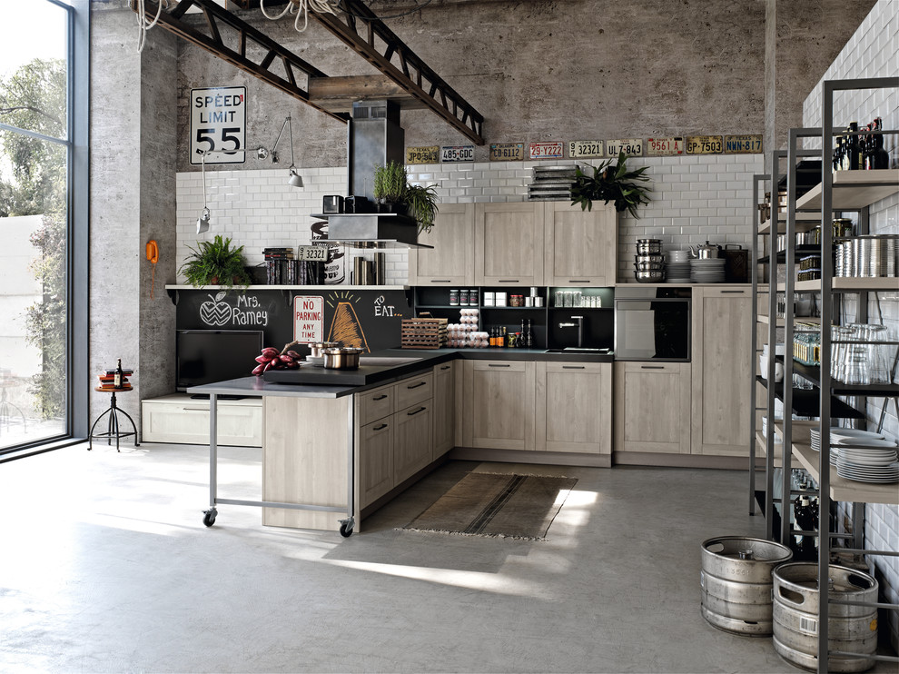 Идея дизайна: кухня в стиле лофт с фасадами с утопленной филенкой, светлыми деревянными фасадами, черным фартуком, черной техникой и бетонным полом