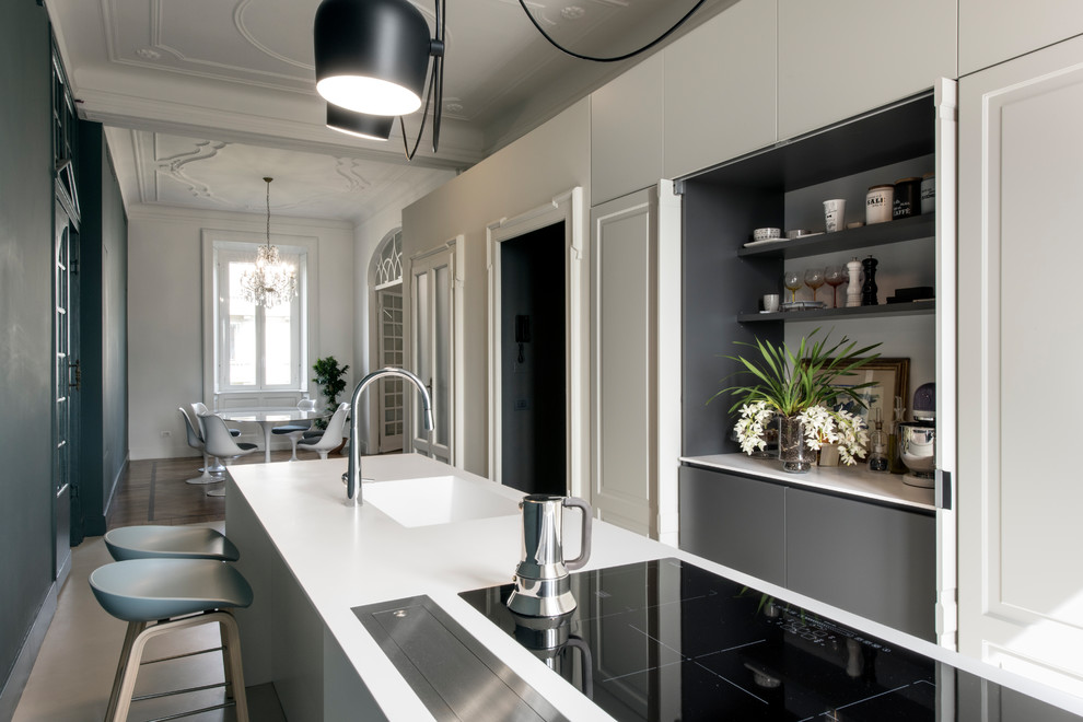 Idéer för mellanstora funkis kök, med en integrerad diskho, luckor med infälld panel, vita skåp, bänkskiva i kvarts, rostfria vitvaror, betonggolv, en köksö och flerfärgat golv