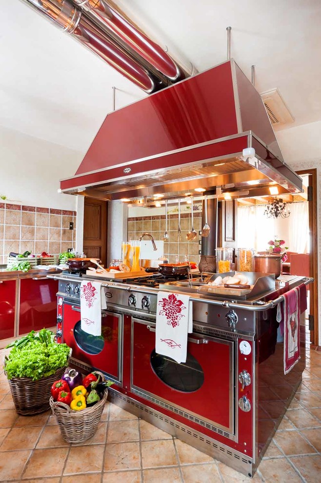 На фото: кухня в классическом стиле с плоскими фасадами, красными фасадами, бежевым фартуком, цветной техникой, островом и бежевым полом с