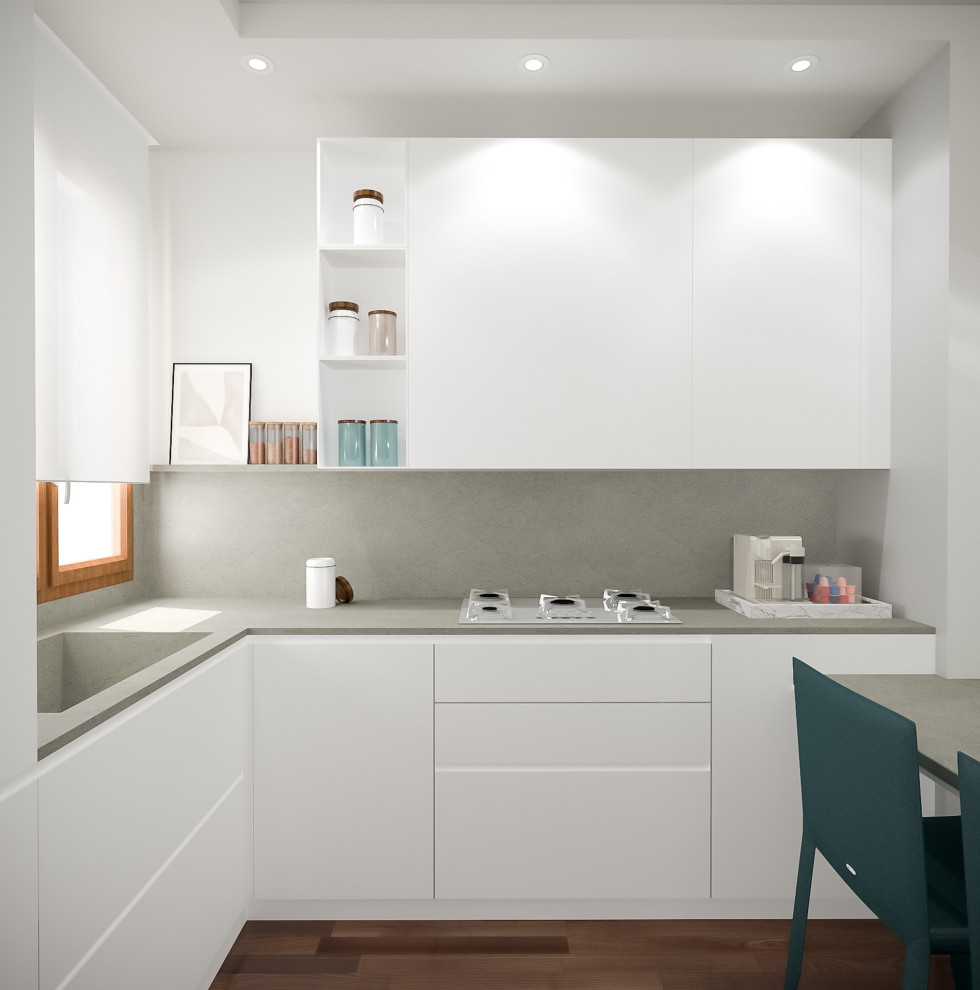 Kleine Moderne Wohnküche in L-Form mit integriertem Waschbecken, flächenbündigen Schrankfronten, Küchenrückwand in Grau, dunklem Holzboden und grauer Arbeitsplatte in Mailand