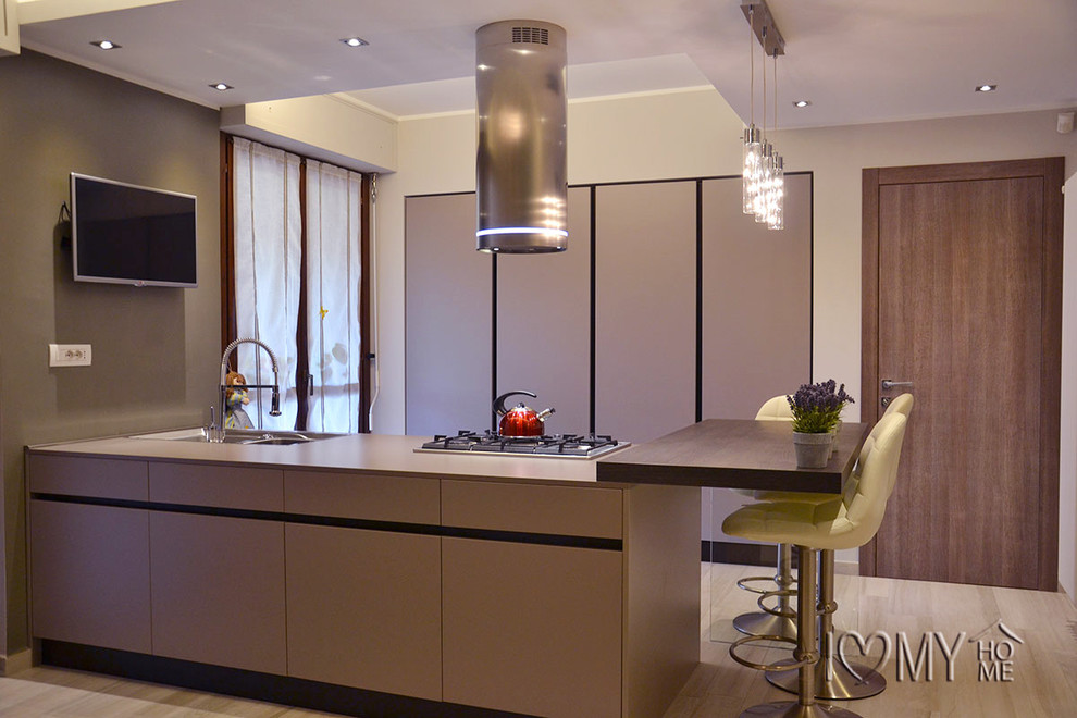 Foto di una cucina minimalista di medie dimensioni con lavello sottopiano, ante lisce, ante beige, elettrodomestici in acciaio inossidabile, parquet chiaro e penisola