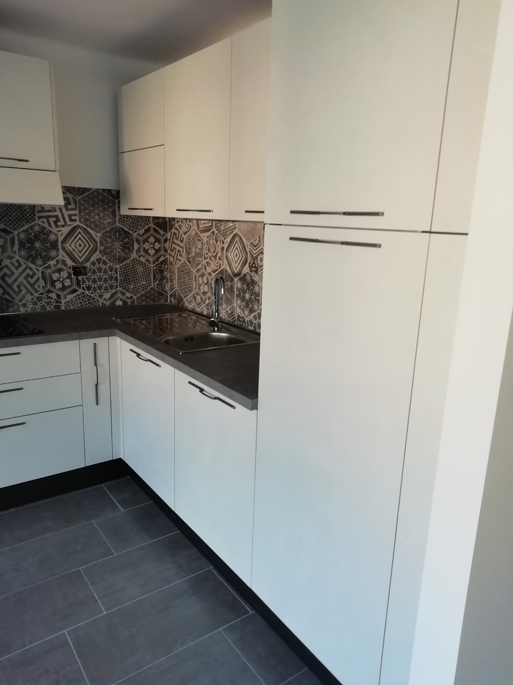 Exempel på ett mellanstort modernt kök, med en nedsänkt diskho, släta luckor, laminatbänkskiva, stänkskydd i cementkakel, rostfria vitvaror, klinkergolv i porslin och grått golv