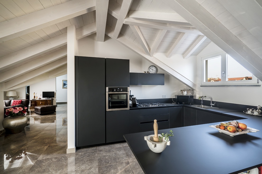 Example of a small beach style u-shaped porcelain tile and gray floor open concept kitchen design in Turin with black cabinets, black backsplash, a peninsula, black countertops and flat-panel cabinets