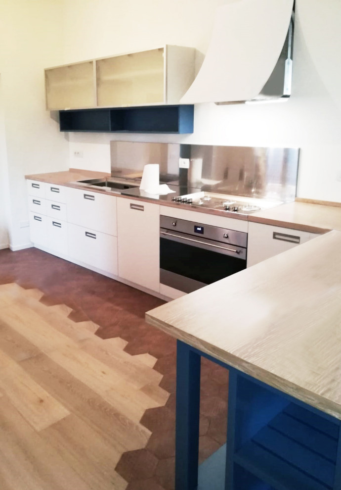 Immagine di una grande cucina lineare minimalista con ante di vetro, ante bianche, top in legno e elettrodomestici in acciaio inossidabile