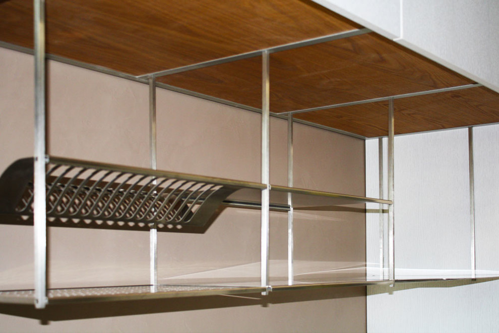 Immagine di una cucina minimal di medie dimensioni con lavello integrato, ante lisce, ante in legno chiaro, top in superficie solida, elettrodomestici in acciaio inossidabile, parquet chiaro e top bianco